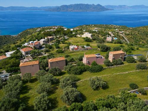 an aerial view of a small village on a hill next to the water at Aegina Colors in Sfendoúrion