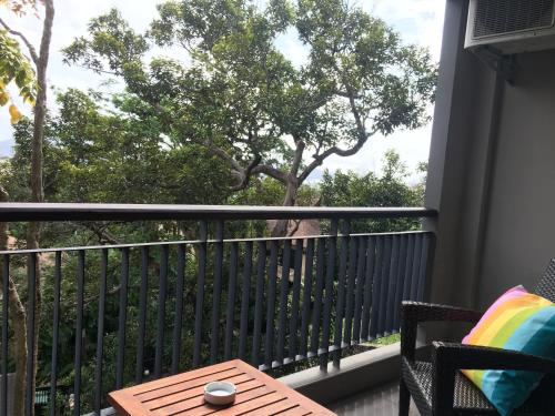 a balcony with a table and a tree at Baan Andaman Sea Surf in Patong Beach