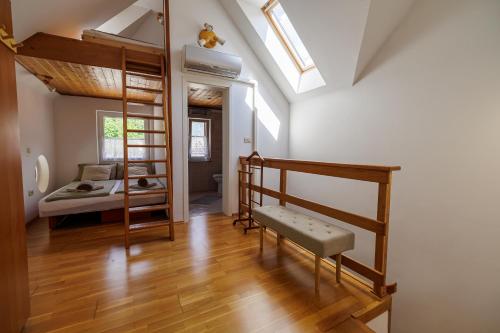 a room with a bunk bed and a bedroom with a ladder at Holiday Home Katja in Srpenica