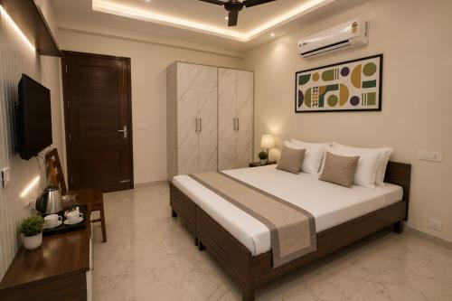 a bedroom with a large bed and a television at Hotel IT Park Home Stay Near DLF City Centre Mall in Manī Mājra