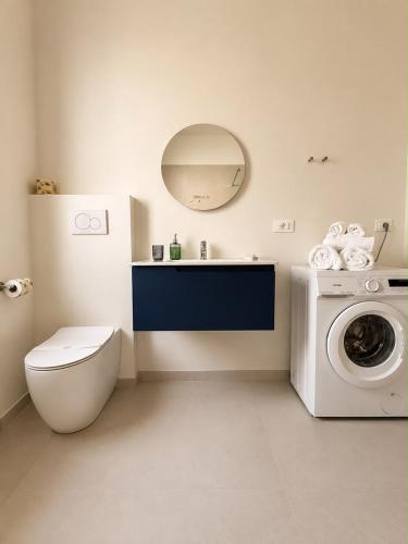 a bathroom with a toilet and a washing machine at Giuditta Apartment in Ciriè