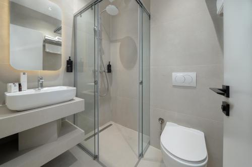ein Badezimmer mit Toilette, Waschbecken und Dusche in der Unterkunft Fly Inn Hotel in Vragolija