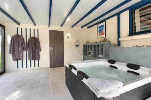 a bathroom with a large tub in a room at Gîte Ressources - Jacuzzi in La Frenaye