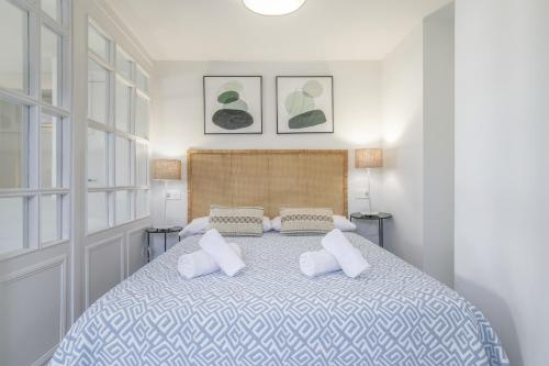 a white bedroom with a large bed with pillows at Ático Pedro Romero in Ronda