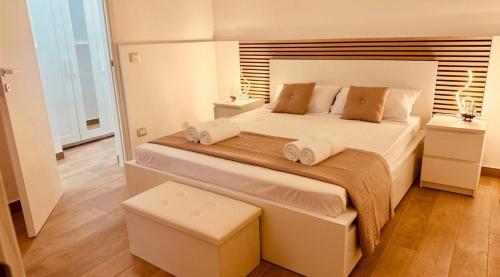 a bedroom with a large bed with two pillows at Faraglioni Bay in Acitrezza