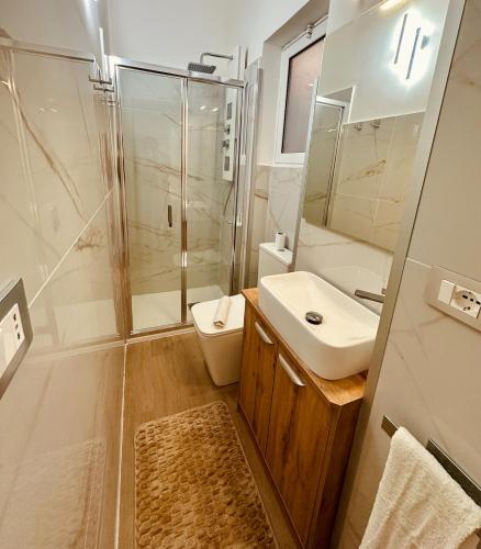 a bathroom with a shower and a sink and a toilet at Faraglioni Bay in Acitrezza