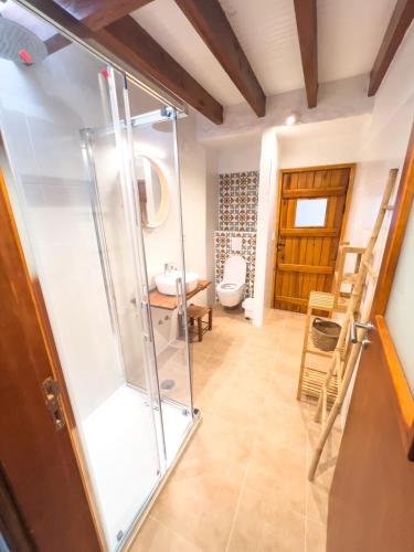 a bathroom with a glass shower and a toilet at Palmeira Nature Lodge in Tavira