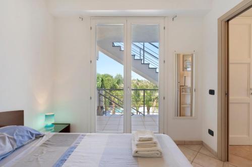 a white bedroom with a bed and a staircase at Casa Marea in Marzamemi