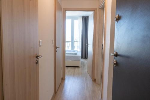 a hallway with a room with a bed and a window at Seaforth Apartment in Siófok