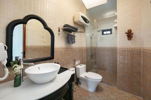 a bathroom with a sink and a toilet and a shower at Maison Bay View Villa Cat Ba in Ðồng Khê Sâu