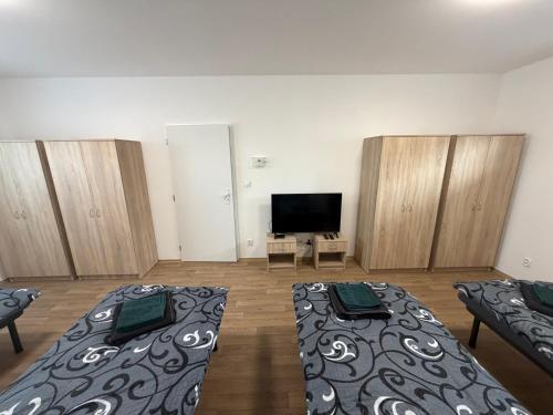 a room with two beds and a flat screen tv at Apartmány U Praisů in Františkovy Lázně
