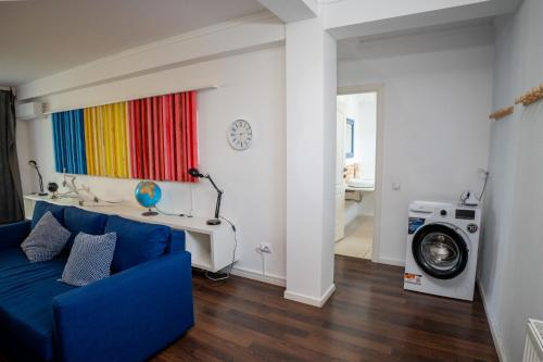 a living room with a blue couch and a washing machine at Barrique 24-4 - Breakfast delivered & Minibar - Free Parking -Officially classified guesthouse in Braşov