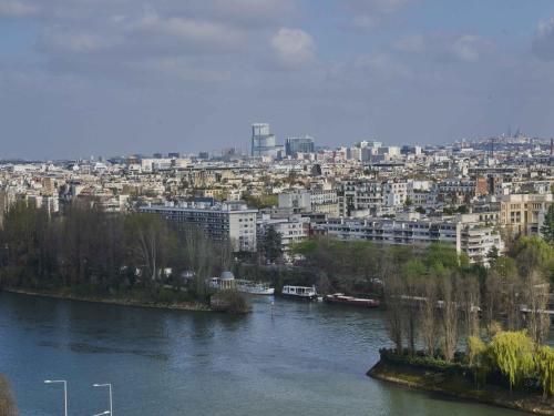 a view of a city with a river and buildings at Fraser Suites Paris La Défense in Courbevoie