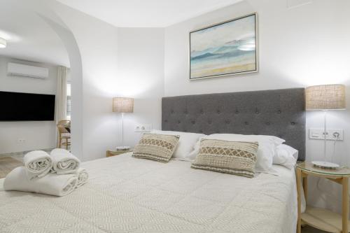 a bedroom with a large bed with towels on it at Vicente Espinel Apartment in Ronda