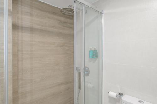 a shower with a glass door in a bathroom at Vicente Espinel Apartment in Ronda