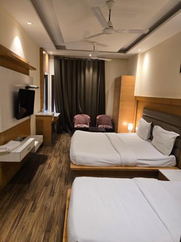 a hotel room with two beds and a television at my divine hotel in Amritsar