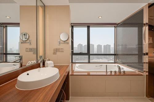 a bathroom with a tub and a large window at Four Points by Sheraton Hangzhou, Binjiang in Hangzhou