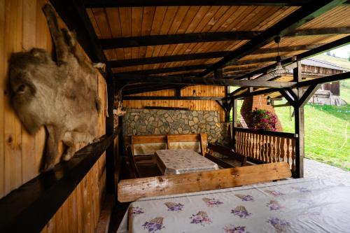 a room with a bed and chairs on a porch at Sapphire Chalet - Moieciu de sus in Moieciu de Sus