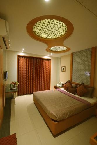 a bedroom with a large bed and a large window at Hotel City Heart Shirdi in Shirdi