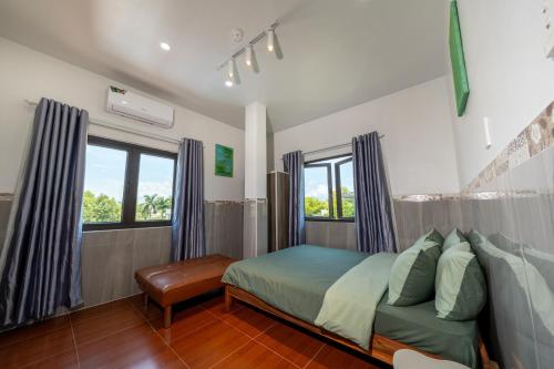 a bedroom with a bed and two windows at Danna House Da Nang BNB in Danang