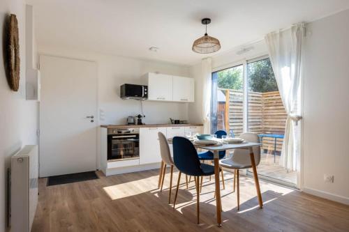 a kitchen and dining room with a table and chairs at L'Écume - Cocon breton avec terrasse in Saint-Avé