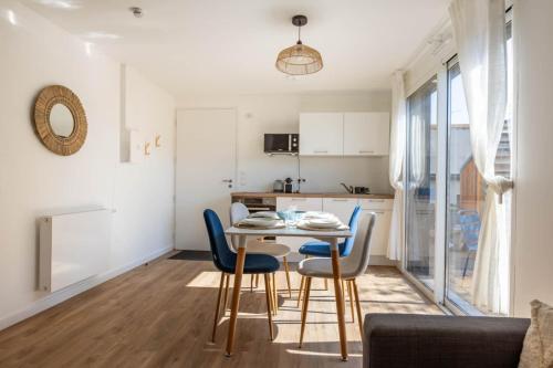a kitchen and dining room with a table and chairs at L'Écume - Cocon breton avec terrasse in Saint-Avé