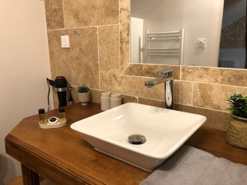 a bathroom with a white sink and a mirror at Gîte 4 personnes in Brantôme