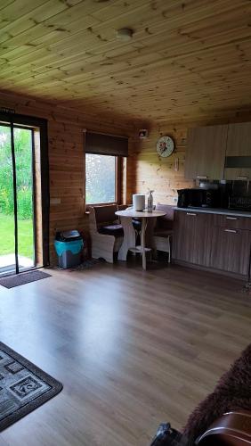 a room with a kitchen and a table in a cabin at Vasarnīca Pie Anniņas in Pasteri
