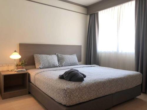 a bedroom with a bed with a large window at Sunday Ayothaya Hotel in Phra Nakhon Si Ayutthaya