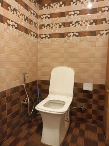 a bathroom with a white toilet in a room at Hotel Pine View Villa in Dagshai