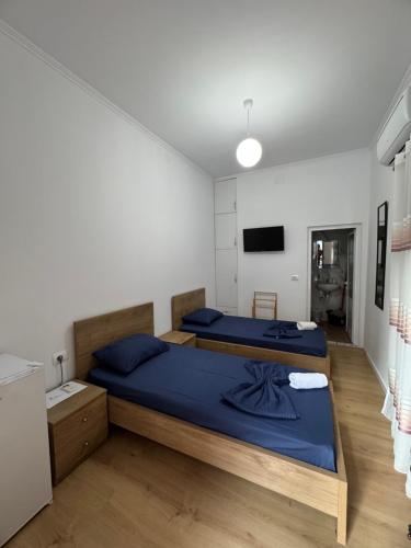 a bedroom with two beds and a tv at Central Rooms Permet in Përmet