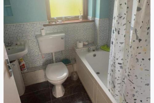 a bathroom with a toilet and a tub and a sink at North Dublin 2-Bed House Sleeps 4 in Dublin