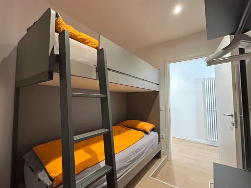 a bedroom with a bunk bed with yellow sheets at Rivacentro 4 in Riva del Garda