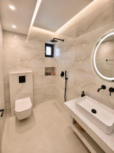 a bathroom with a sink and a toilet and a mirror at Amara 2 bedrooms apartment - Alykanas in Alikanas