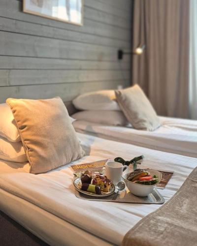 a tray of food on a bed with two beds at Hotell Rådhuset in Lidköping