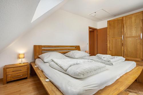 a large bed with white sheets and pillows on it at Haus 29 in Röbel