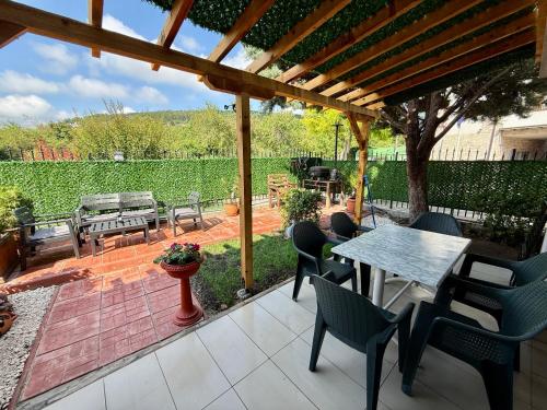 a patio with a table and chairs and a wooden pergola at The Lemon Villa in Rogachevo