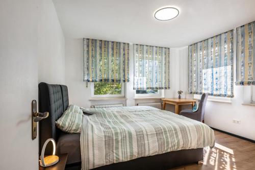 ein Schlafzimmer mit Bett, Tisch und Fenstern in der Unterkunft Hoffmanns in Burgkirchen an der Alz
