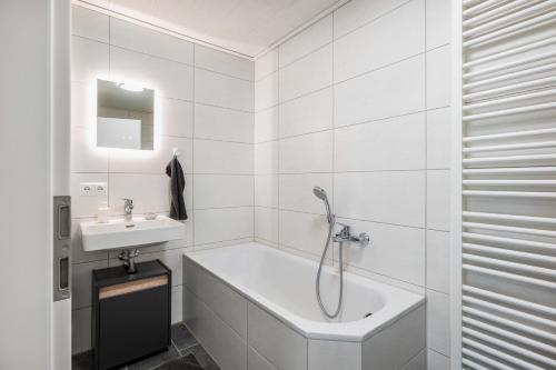 ein weißes Badezimmer mit Badewanne und Waschbecken in der Unterkunft Hoffmanns in Burgkirchen an der Alz