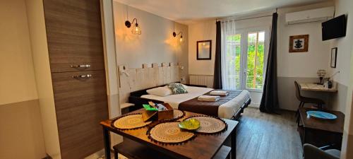 a room with a bed and a table with plates on it at Logis Le Nid du Pont de Gau in Saintes-Maries-de-la-Mer