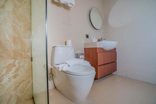 a bathroom with a toilet and a sink at Anandani Suites in Canggu