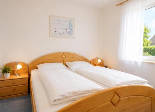 a bedroom with a wooden bed with two white pillows at FeWo kleine Auszeit in Cuxhaven