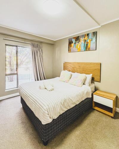 a bedroom with a large bed and a window at Zion on Mayfair in Cape Town