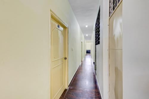 a hallway with a yellow door and a tile floor at SPOT ON Ganesh in Kaglipur