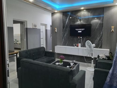 a living room with two couches and a flat screen tv at Résidence keur Saloum in Thiès