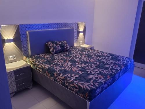 a bedroom with a purple bed with two lamps at Résidence keur Saloum in Thiès