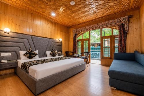 a bedroom with a large bed and a couch at Srichan Resorts in Pahalgām