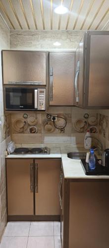 a kitchen with stainless steel cabinets and a microwave at شاليهات رميس in Abha