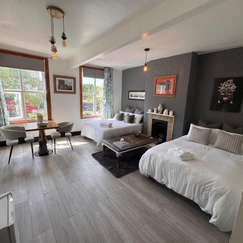 a bedroom with two beds and a living room at The Cloud in Alderley Edge