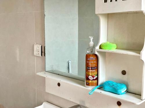 a bathroom with a bottle of soap and a mirror at 2BHK Apartment Perfect for Families & Groups in Rawalpindi